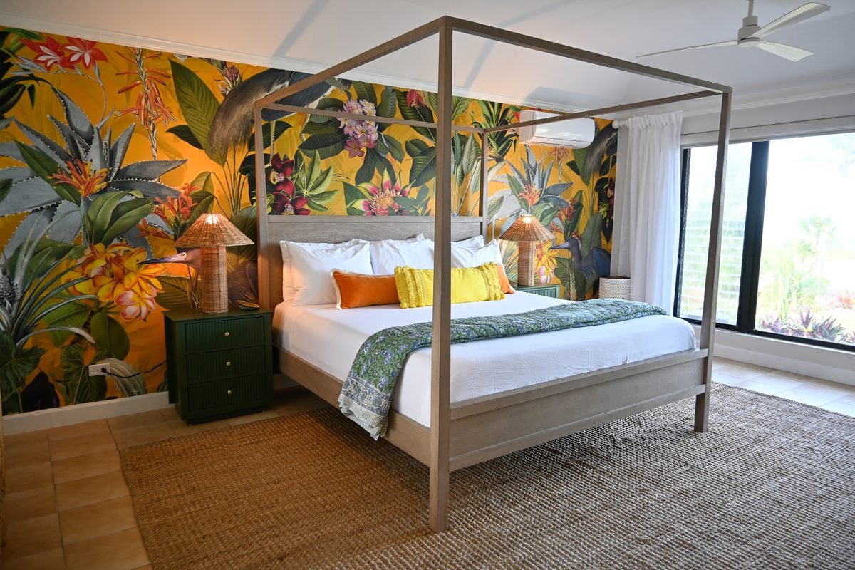 Bird of Paradise Suite canopy bed with tropical wallpaper at Hightide Estate