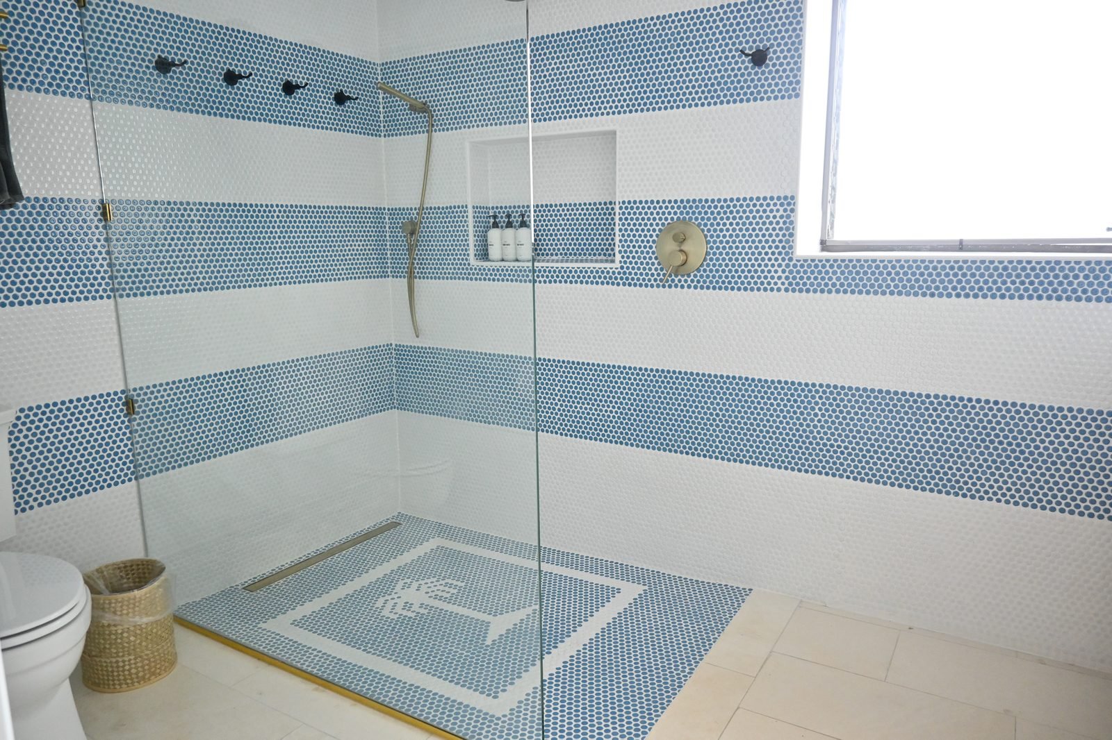 Walk-in shower with blue and white striped tile