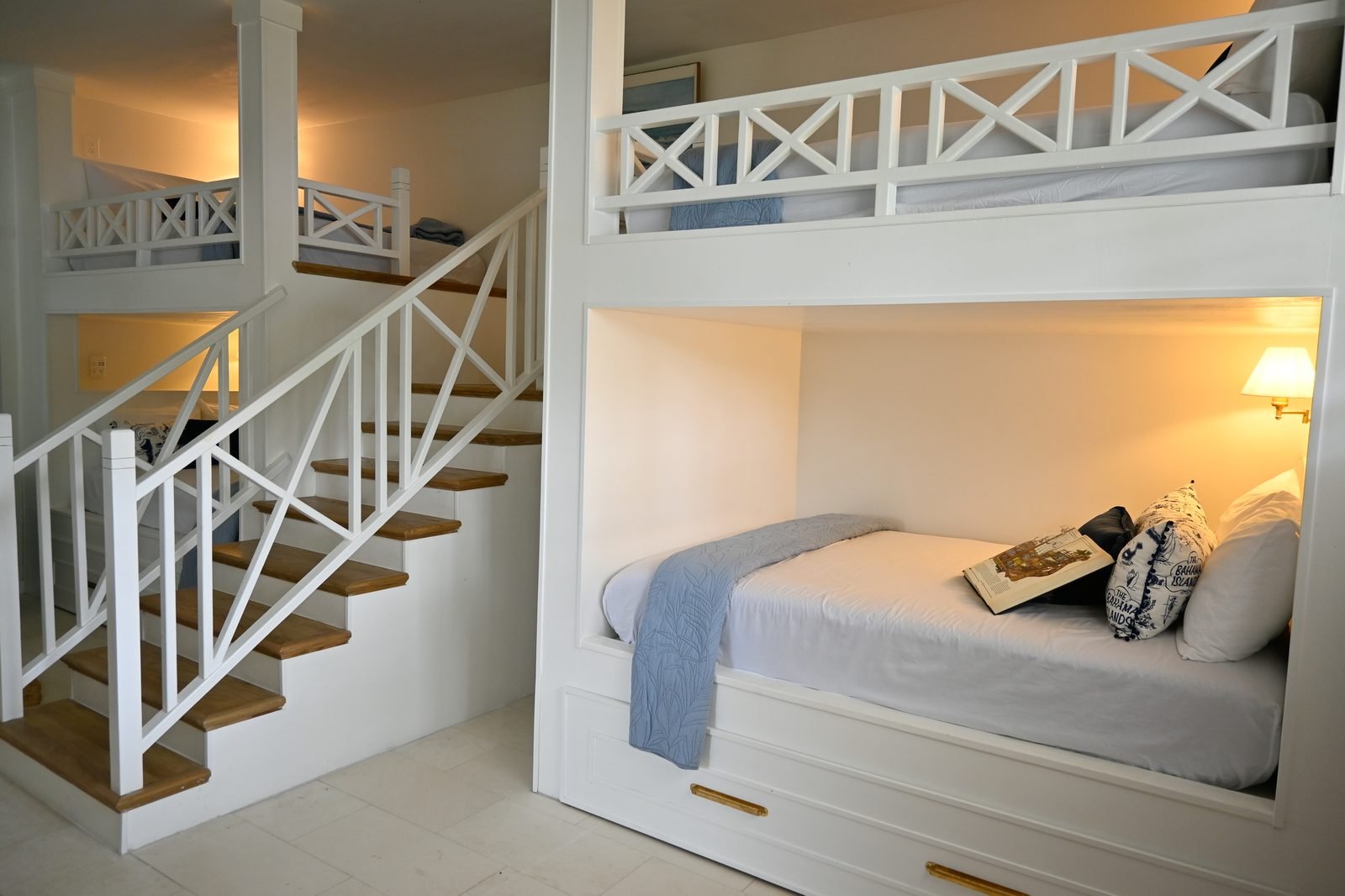 Built-in bunk beds with stairs and white X-railings at Hightide Estate