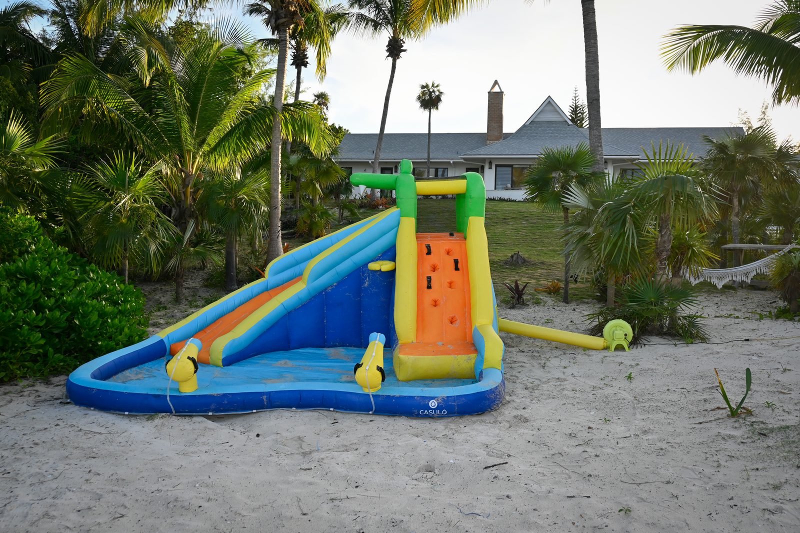 Inflatable waterslide on private beach at Hightide Estate — family-friendly fun