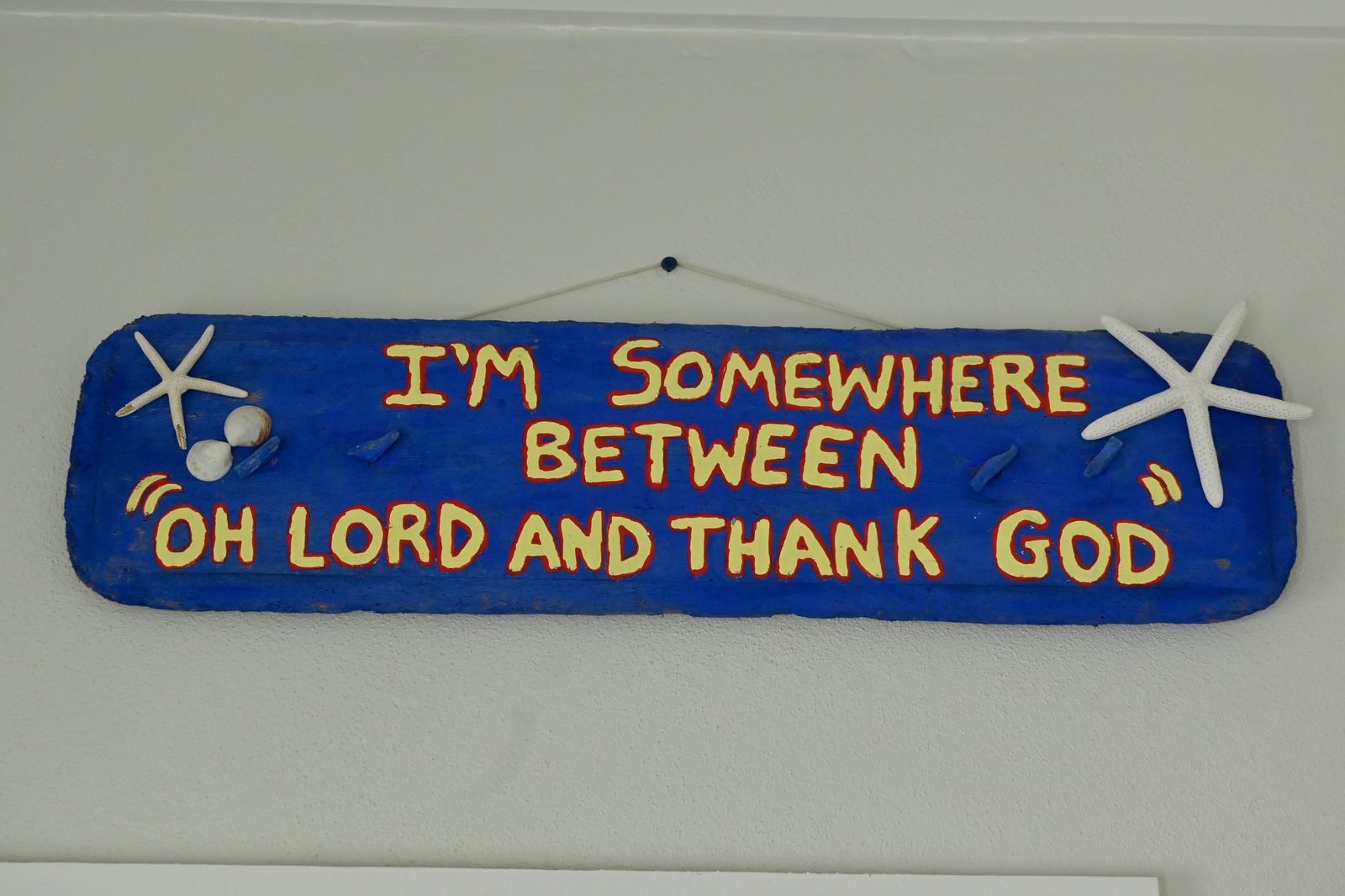 Hand-painted sign: I'm somewhere between oh lord and thank God — Hightide Estate personality