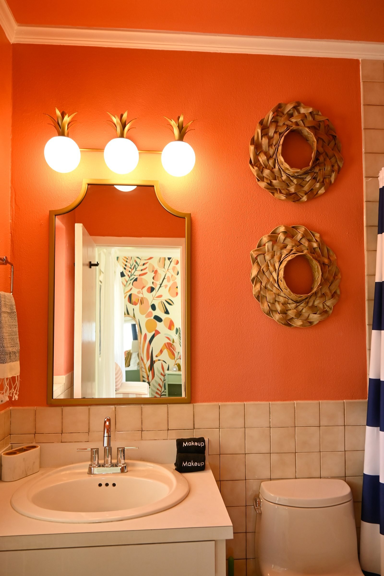 Pineapple Suite ensuite — sun wreath mirrors and coral walls